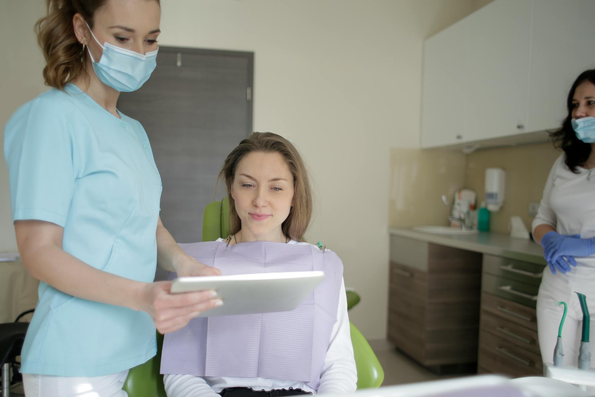 dentist showing patient information on a tablet