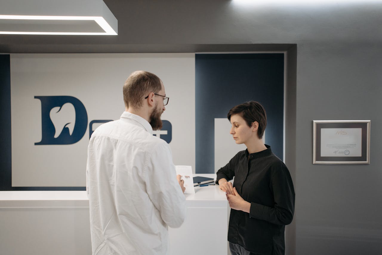 dentist and patient are talking inside a dental clinic
