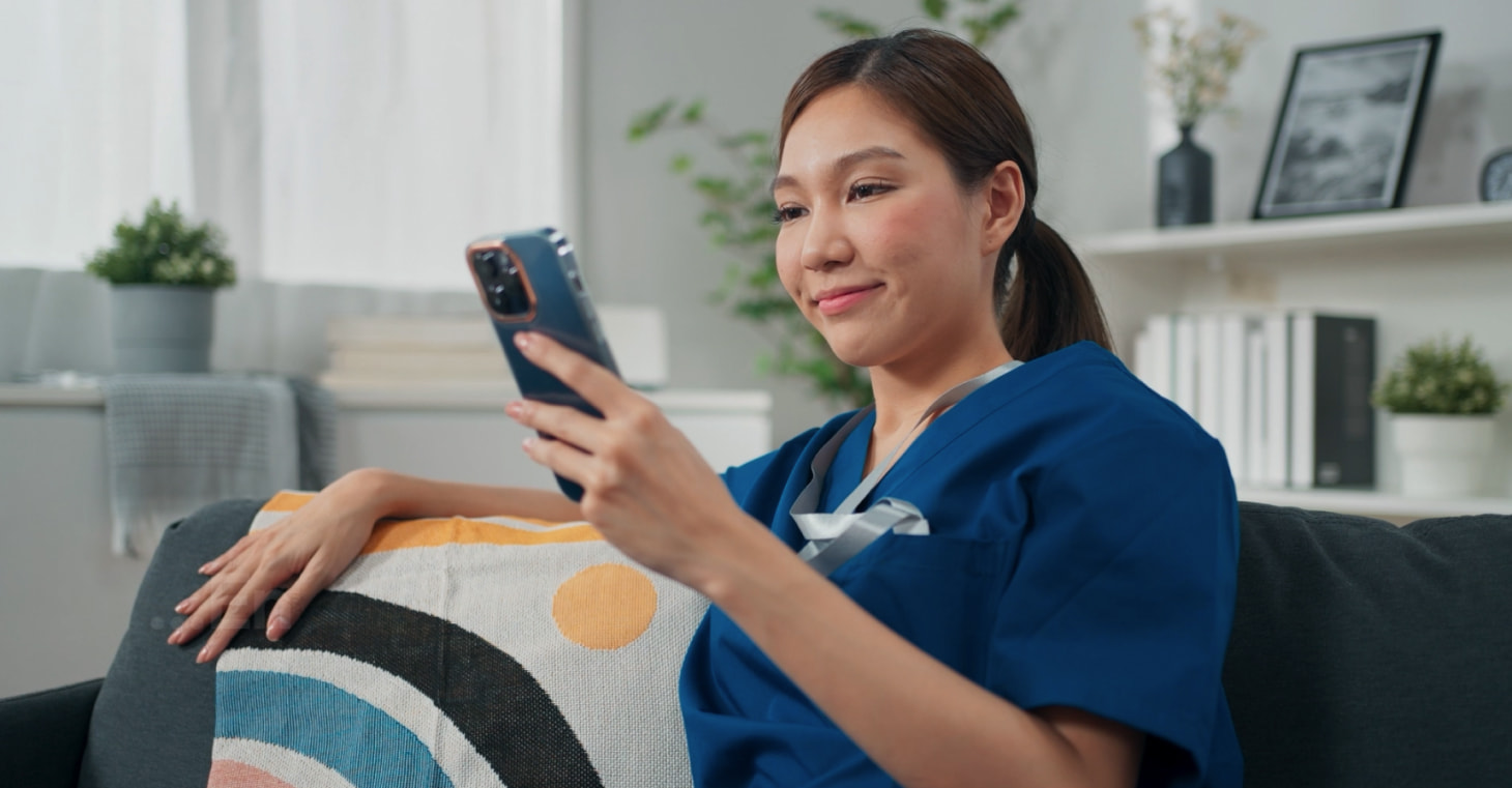 Dental professional in scrubs checking shifts on her smartphone via the Tempfind app.