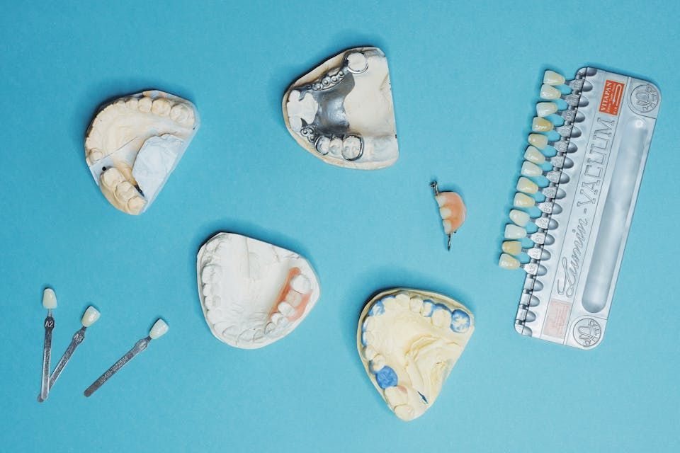 dental tools and dentures on top of a blue table