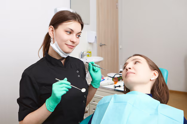 woman dentist holding dental tools while checking teeth female patient cavities